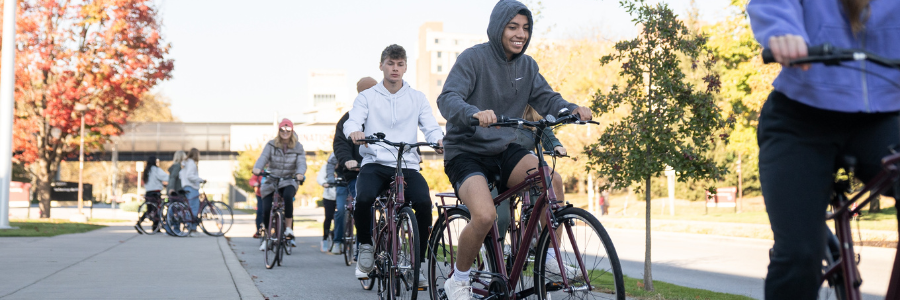 Students riding red IU Indianapolis bikes on campus.