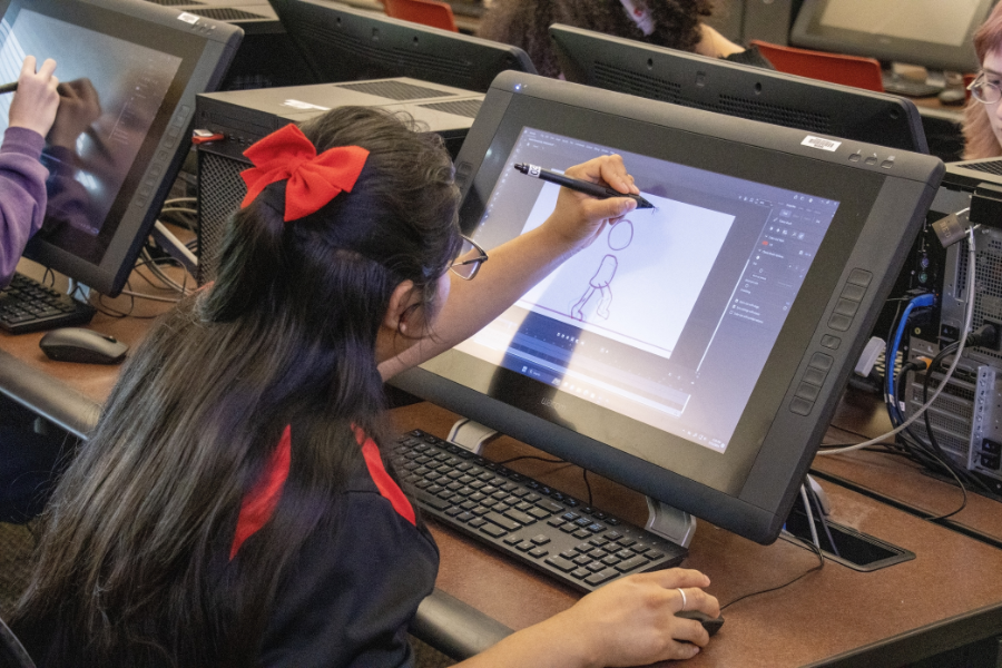 Person sitting at drawing tablet drawing