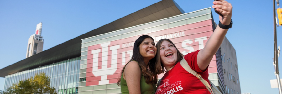 Two female students taking a selfie in front of the IU Indianapolis Campus Center
